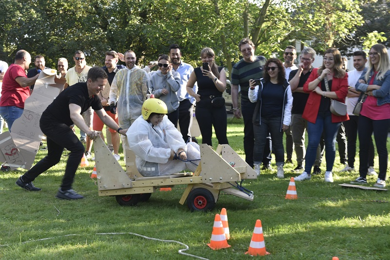 Colleagues race soapboxes together.