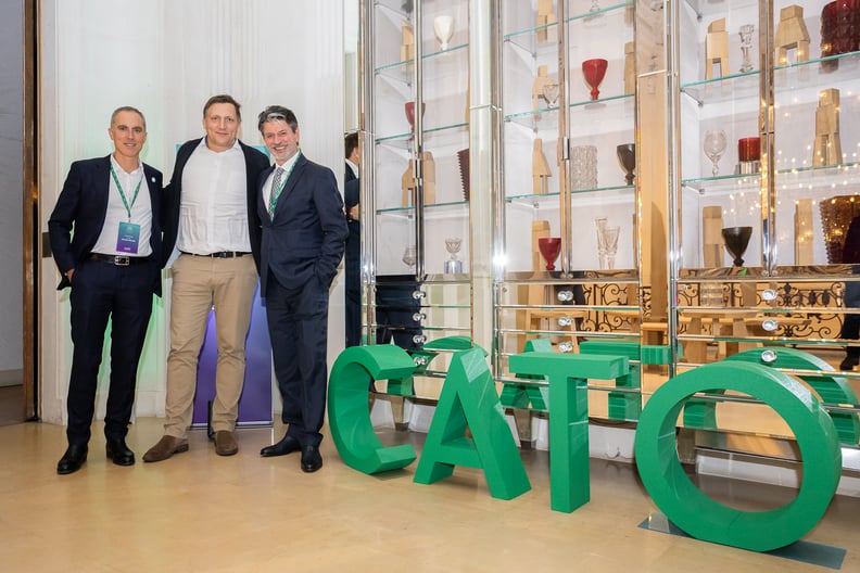 men next to cato logo sign