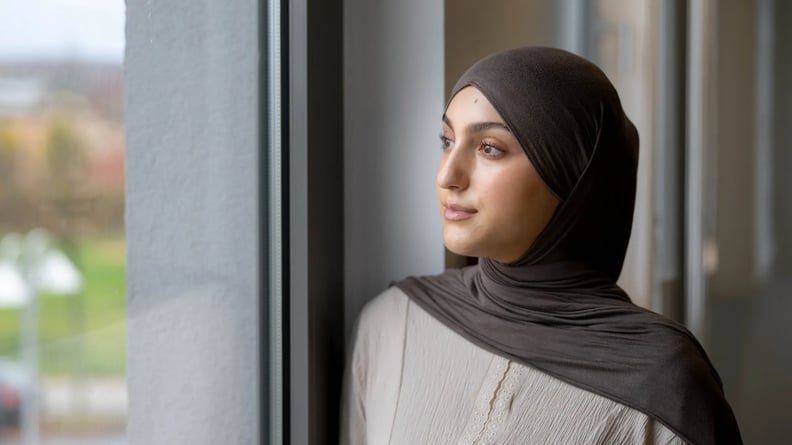Junge Auszubildende schaut nachdenklich aus dem Fenster.