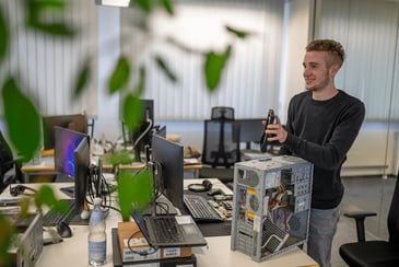 Junger Auszubildender mit Hardware Bestandteilen.