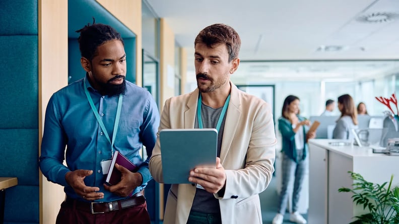 consulting-two-men-walking-discussing-with-tablet