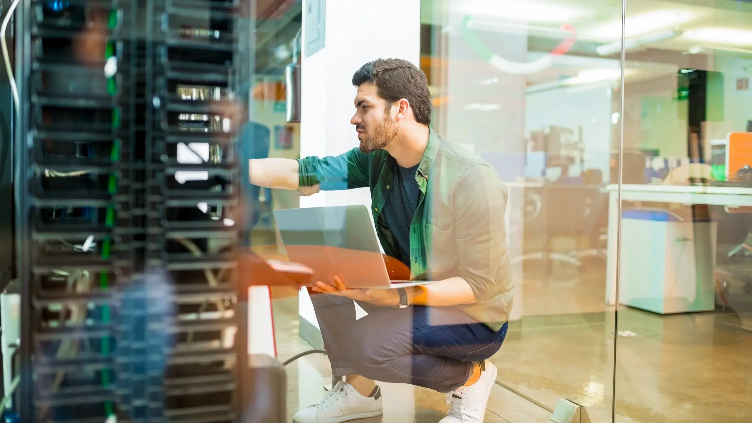 cyber-security-man-crouched-looking-at-server-with-reflection