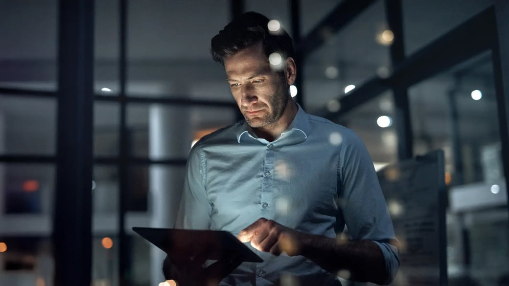 cyber-security-man-looking-at-tablet-in-dark-room-serious