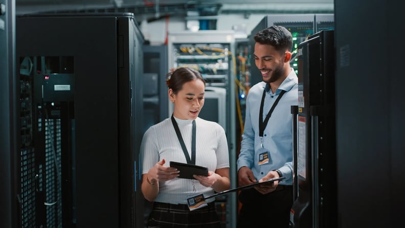 cyber-security-woman-and-man-in-server-room-discussing-happily