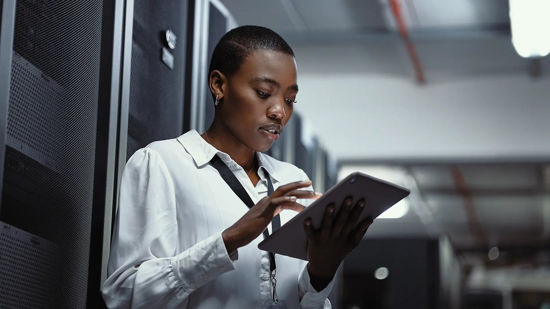 cyber-security-woman-using-tablet-standing-server-room-work-environment