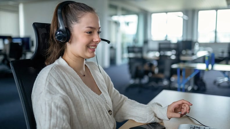 serviceware-woman-with-headset-smiling-on-computer