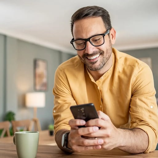 esm-klantenservice-man-huishoudend-smiling-at-phone-square