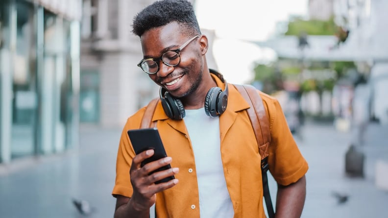 esm-customer-service-man-outside-smiling-at-phone-headphones