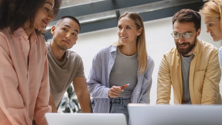 Vijf jonge verkoopstagiairs werken samen aan een casestudy.