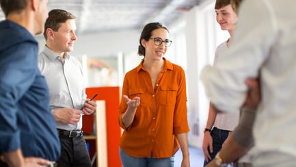 Vijf collega's van de HR-afdeling staan bij elkaar en hebben een ongedwongen gesprek.