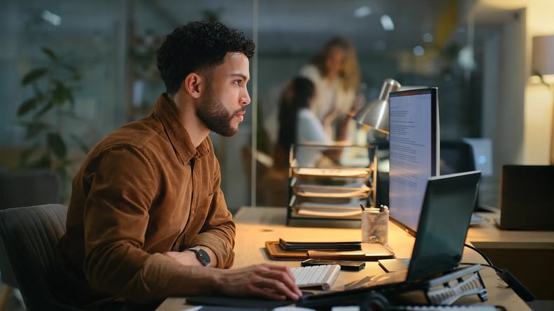 esm-itsm-man-on-computer-in-dark-room-serious