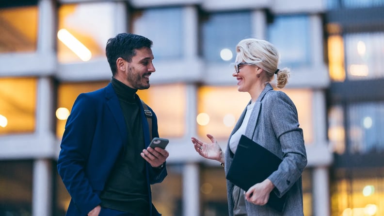 financial-man-and-woman-outside-talking-smiling