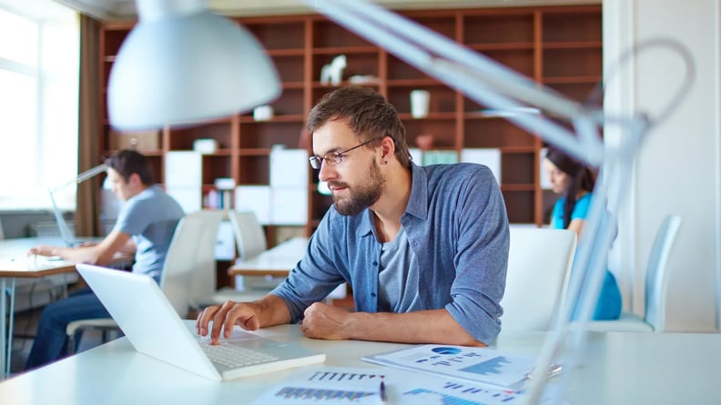 financial-man-on-laptop-with-documents