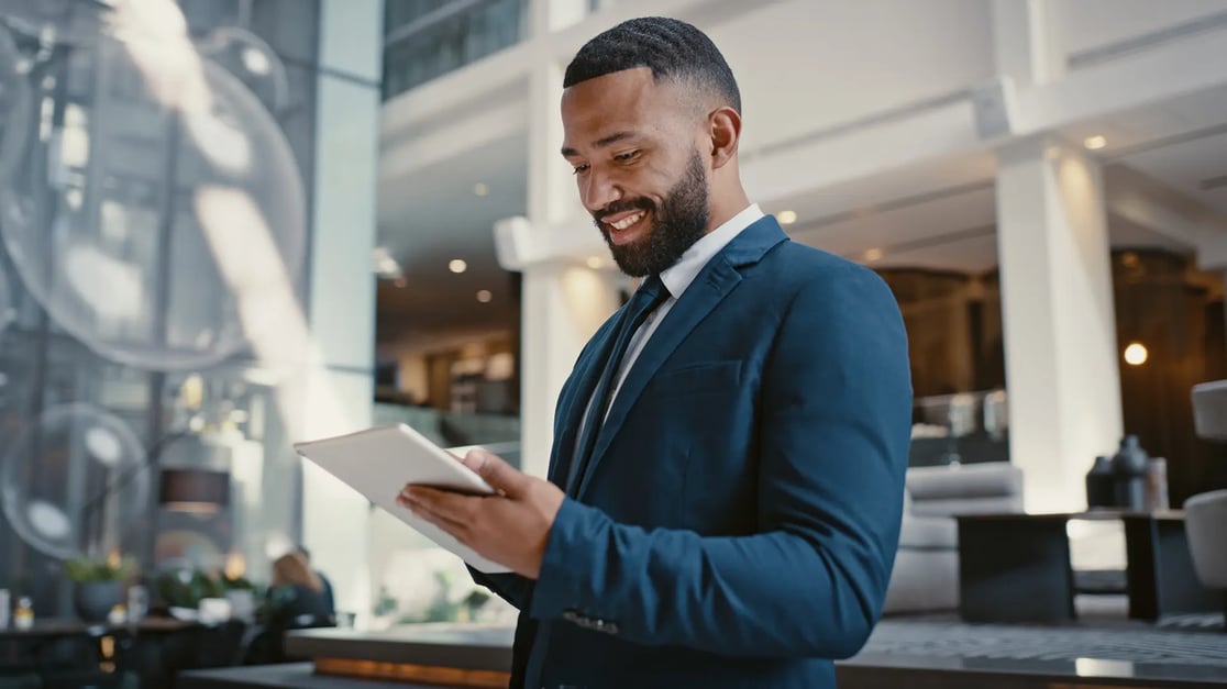 financial-man-standing-smiling-smartphone-suit-work-environment