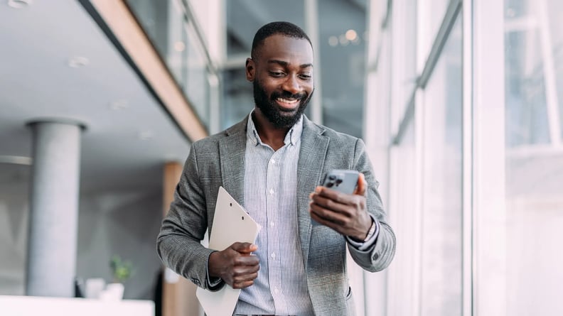 financial-man-walking-smiling-to-phone