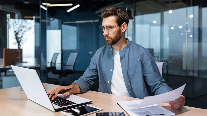 financial-man-with-laptop-and-documents