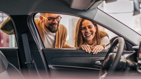industry-man-and-woman-looking-into-car-interior