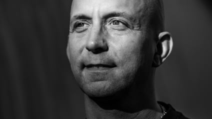 Ein Mann mittleren Alters schaut gelassen nach links.