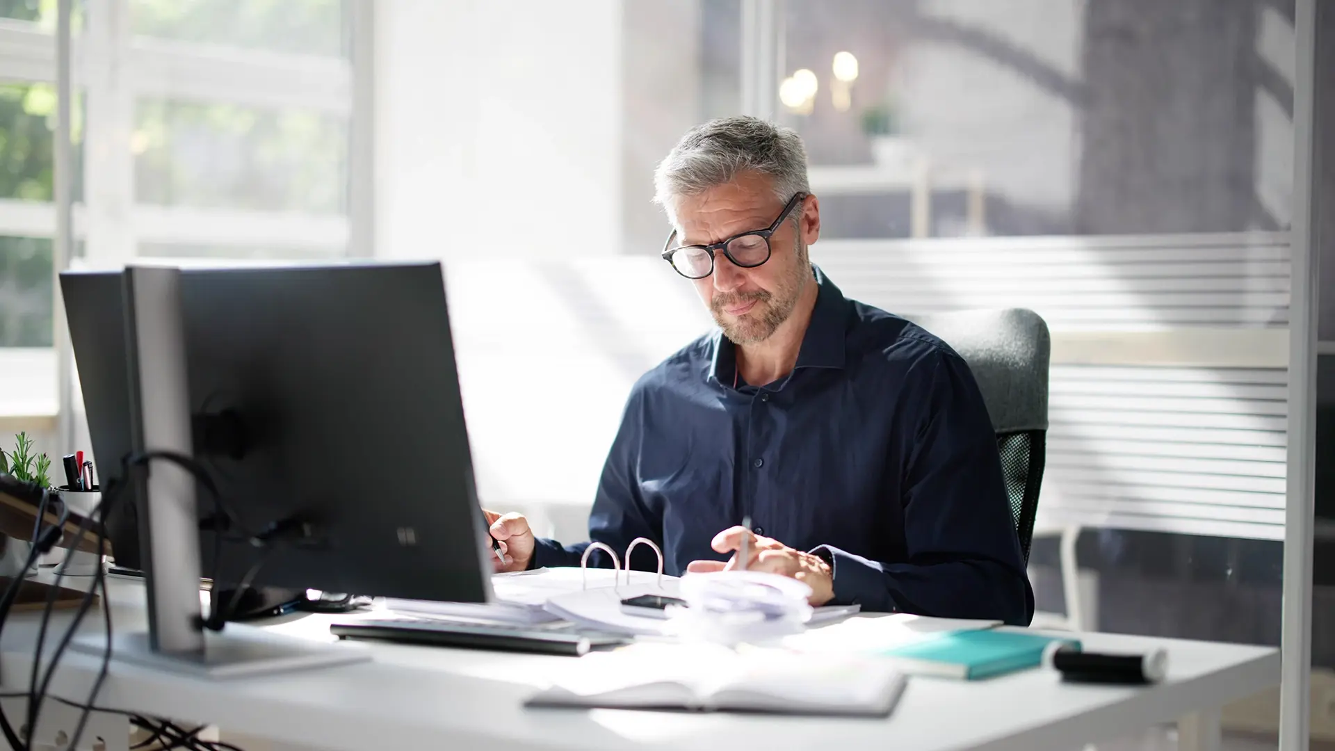 person working at desk with documents