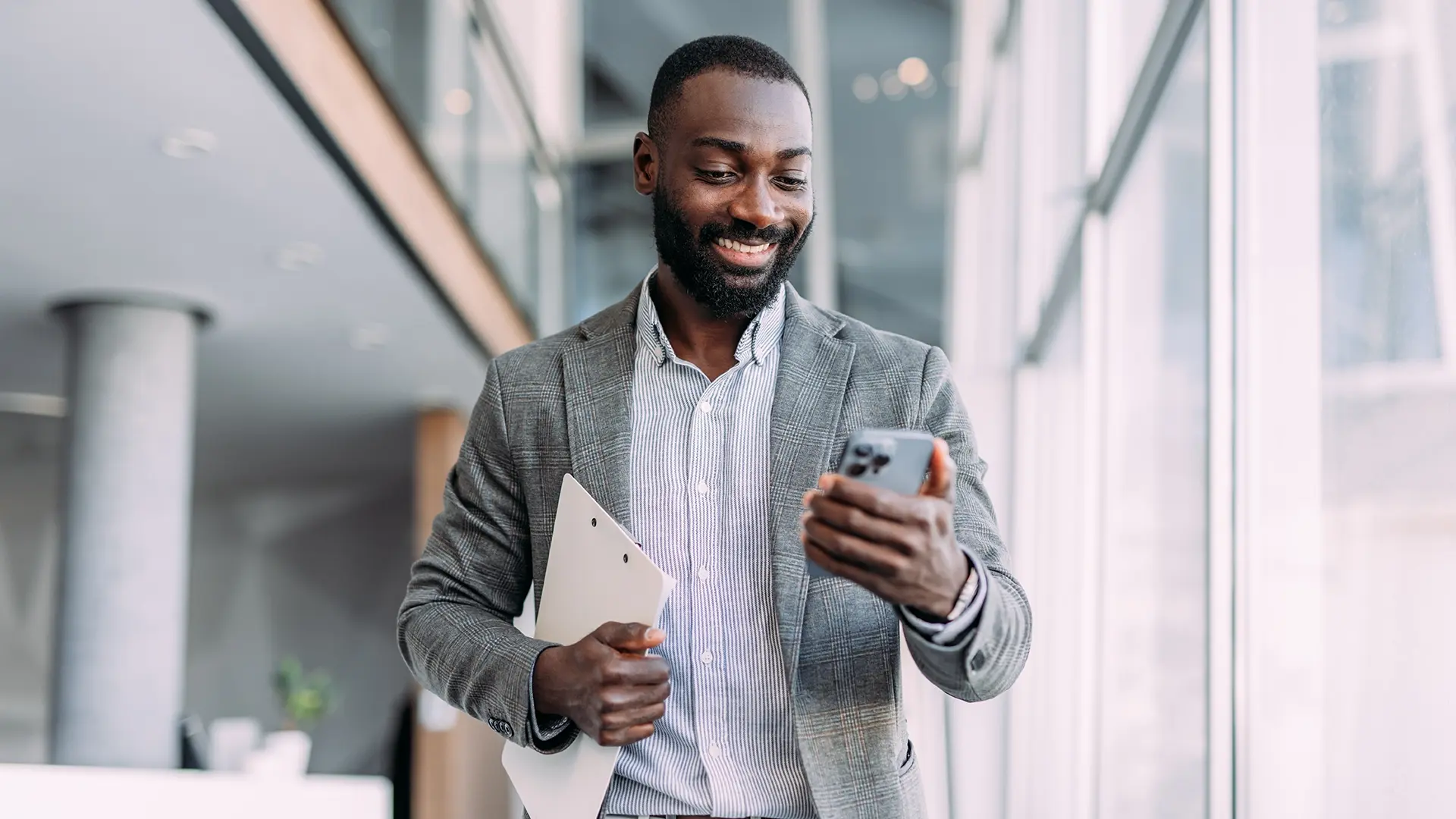 smiling man with smartphone in bright workspace