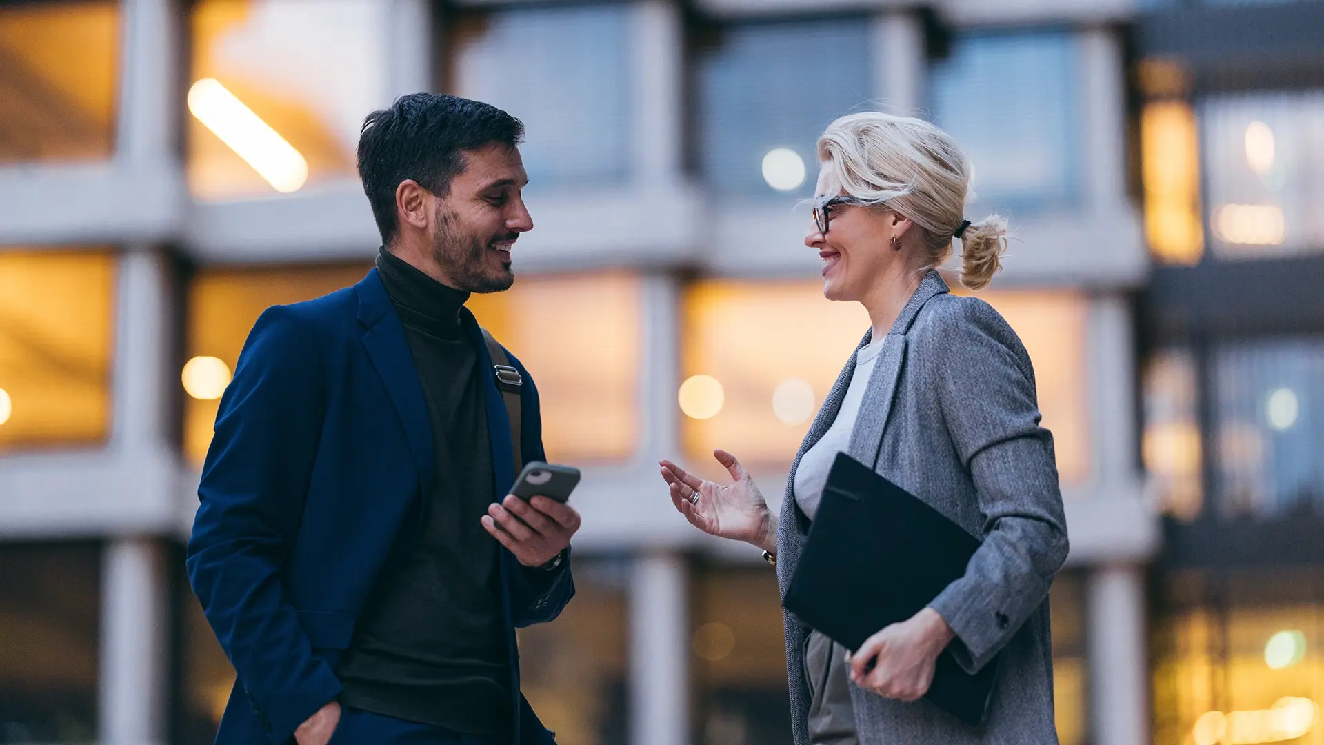 Man and woman outside smiling in conversation