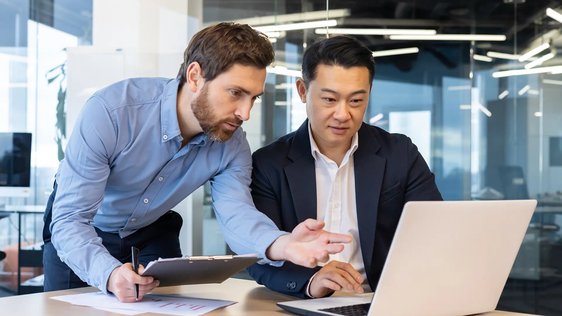 financial-man-group-conversation-laptop-notebook-focused-work-environment