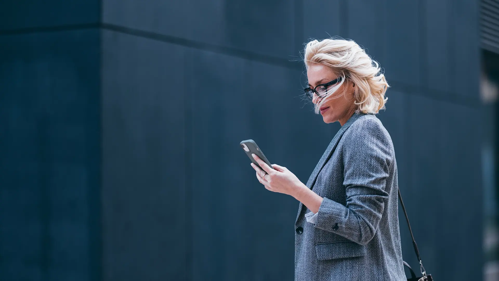 Woman standing outside using smartphone in public