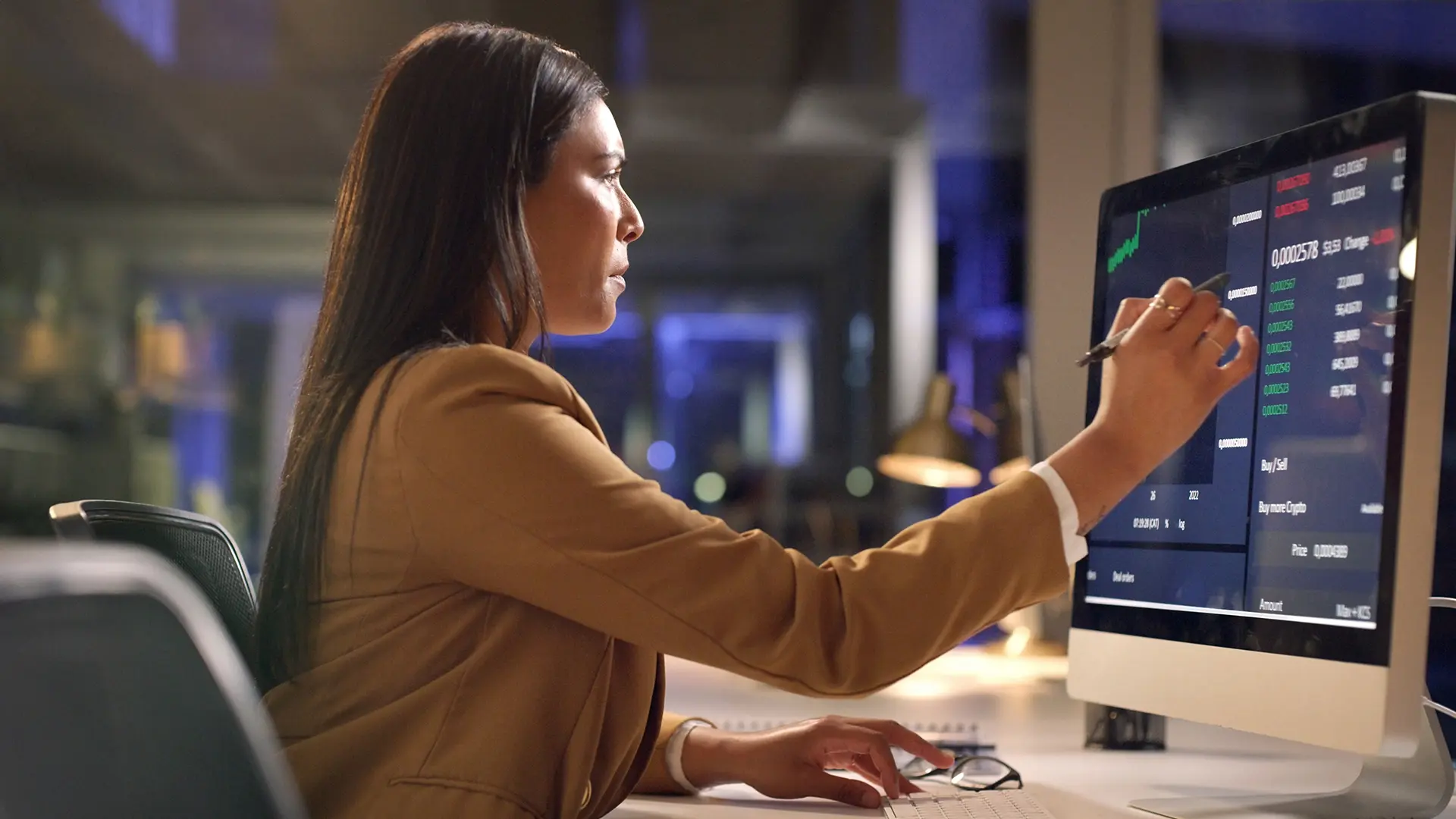 woman sitting desk graphs dark work