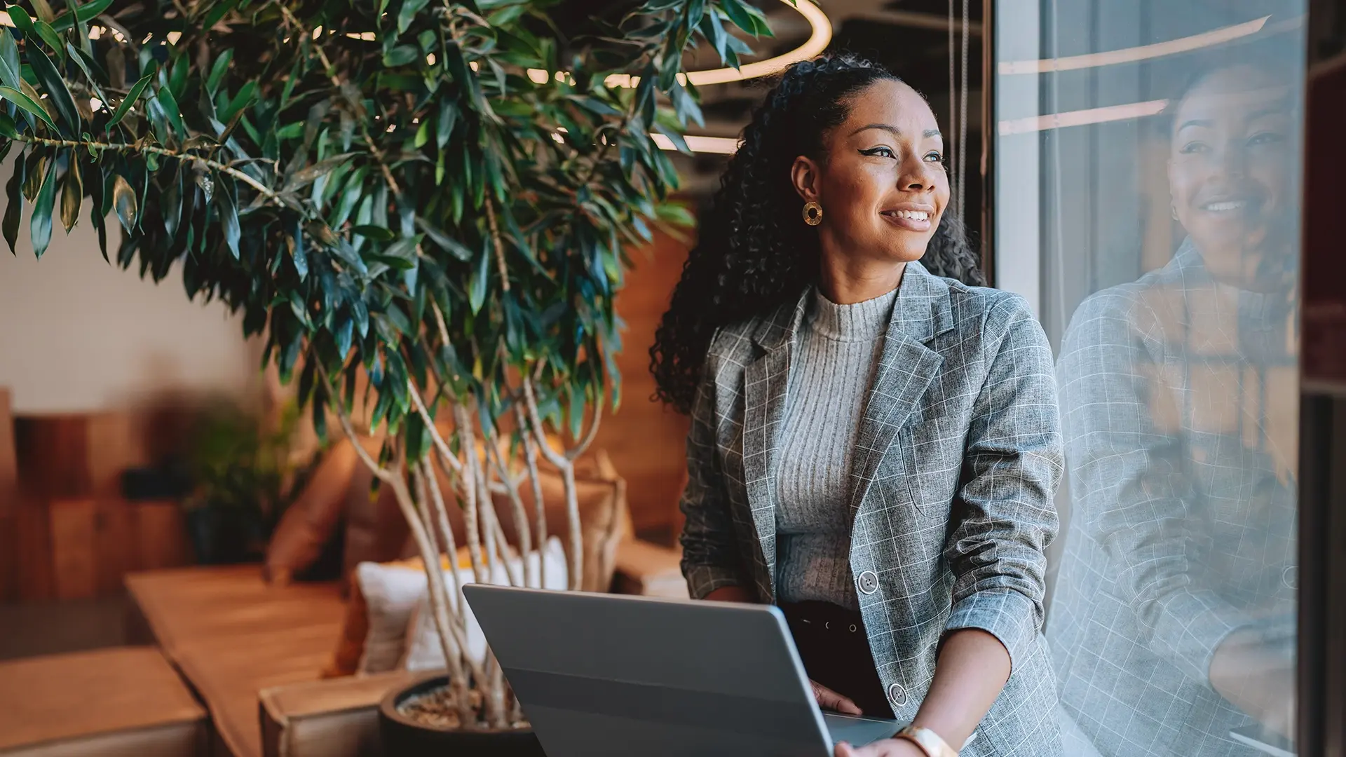 woman using laptop with sunlight coming through window