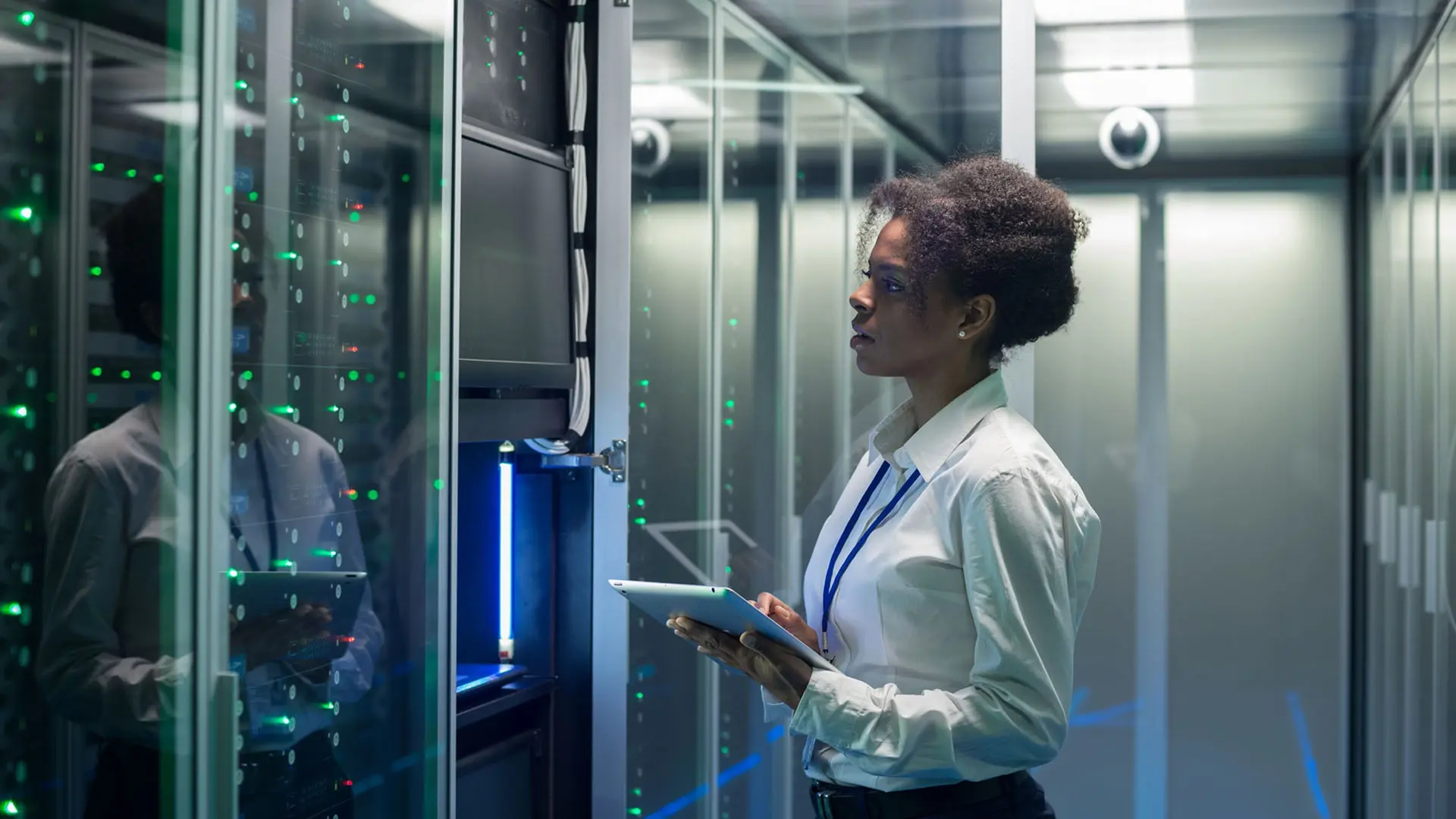 Frau steht mit Tablet im Servicerraum