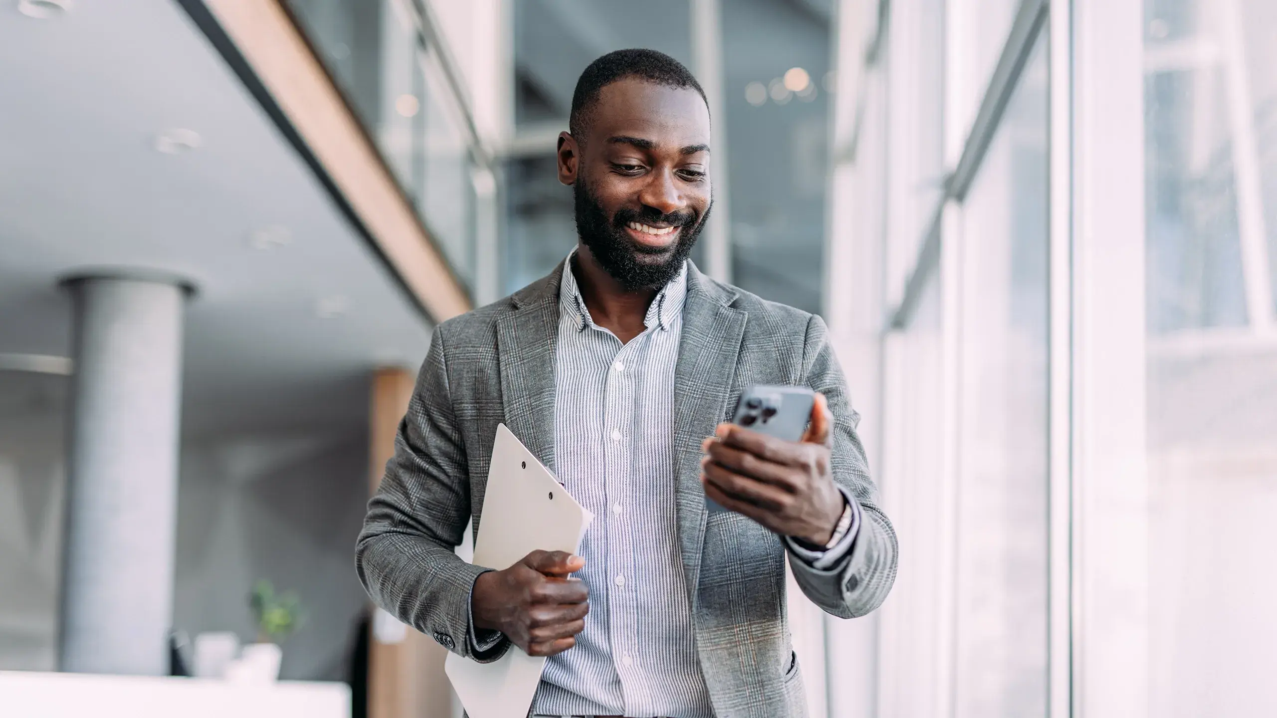 Business Man smiling and looking at his mobile phone